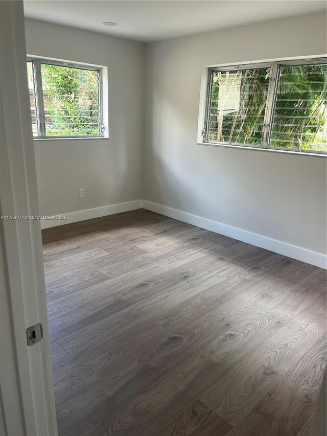 unfurnished room with baseboards and wood finished floors