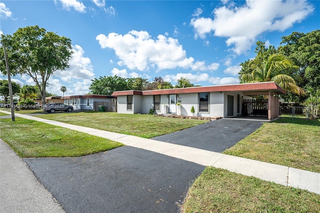 view of front of home with an attached carport, driveway, a front lawn, and stucco siding