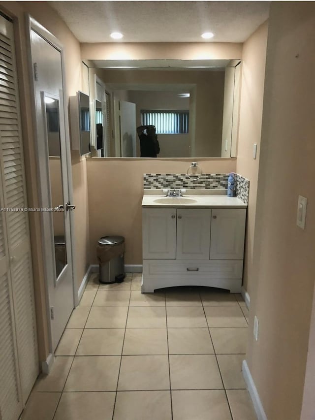 bathroom featuring recessed lighting, vanity, baseboards, and tile patterned floors