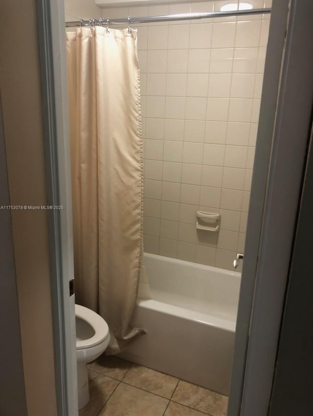 bathroom featuring shower / bath combination with curtain, tile patterned flooring, and toilet