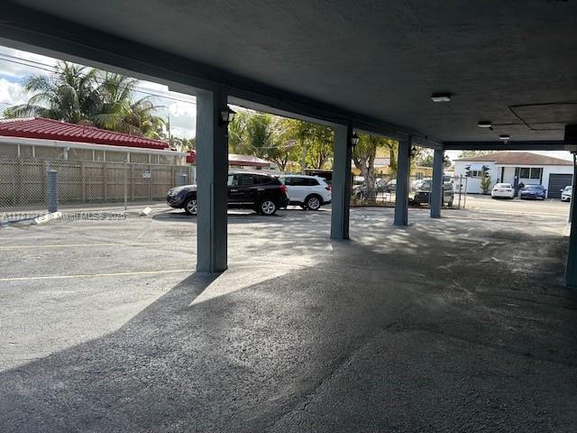 garage featuring uncovered parking and fence