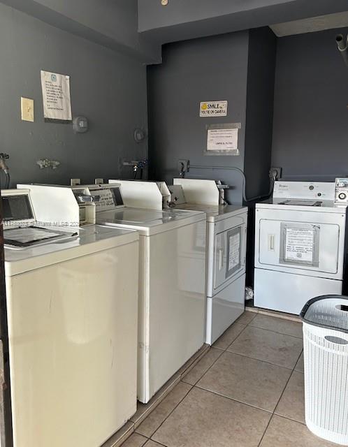 shared laundry area featuring light tile patterned floors and separate washer and dryer