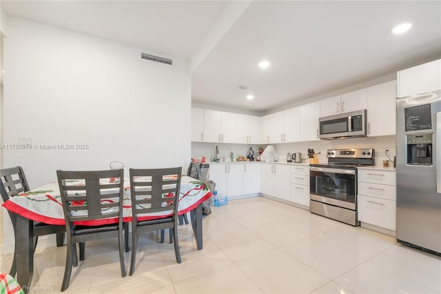 kitchen featuring visible vents, white cabinets, stainless steel appliances, light countertops, and recessed lighting