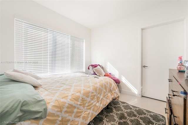 bedroom featuring baseboards and tile patterned floors