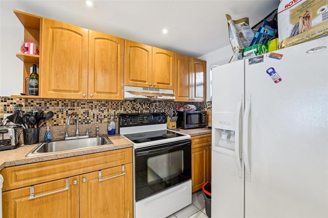 kitchen with electric range, light countertops, under cabinet range hood, white fridge with ice dispenser, and a sink