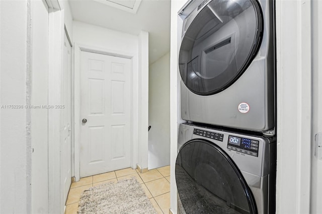 laundry area with light tile patterned floors, laundry area, and stacked washer / drying machine