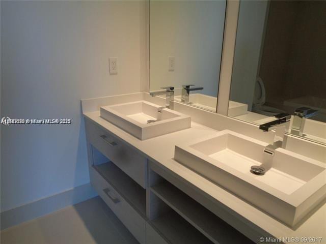 full bathroom with a sink and double vanity