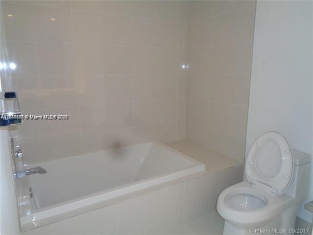 bathroom featuring shower / tub combination and toilet