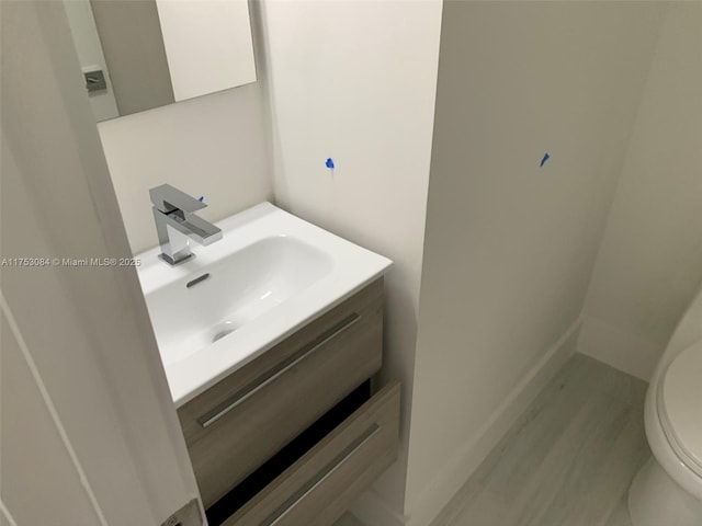 half bathroom with vanity and toilet