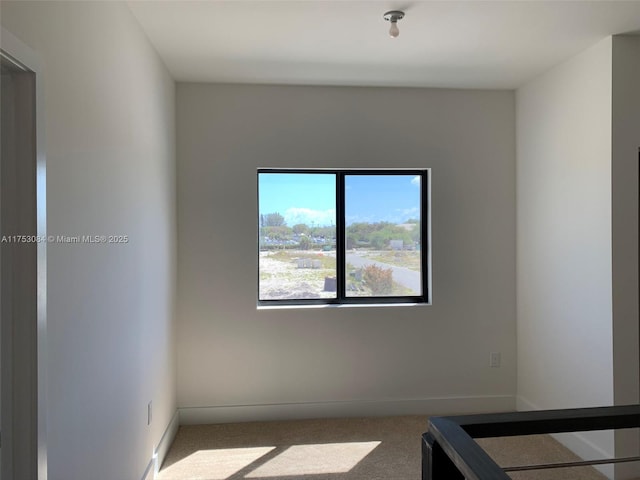 unfurnished room featuring baseboards and carpet
