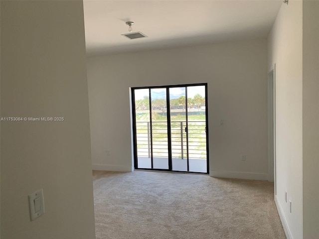 spare room with baseboards, carpet flooring, and visible vents
