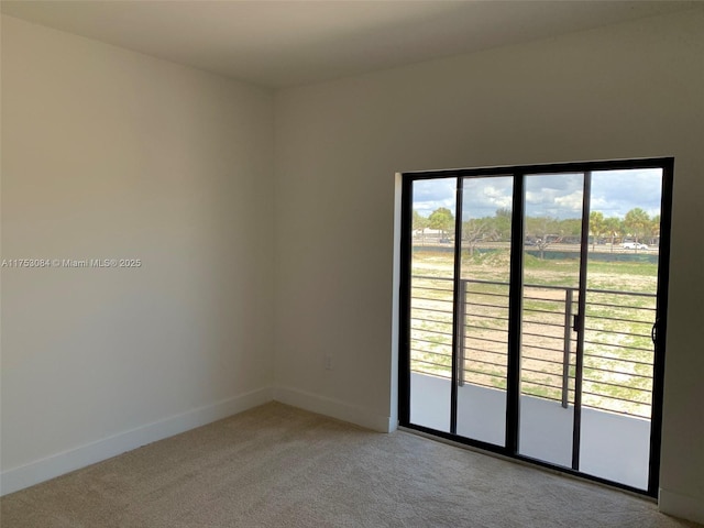 spare room featuring baseboards and light colored carpet