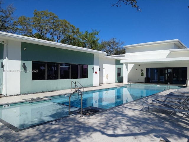 exterior space with a community pool, a patio, and stucco siding