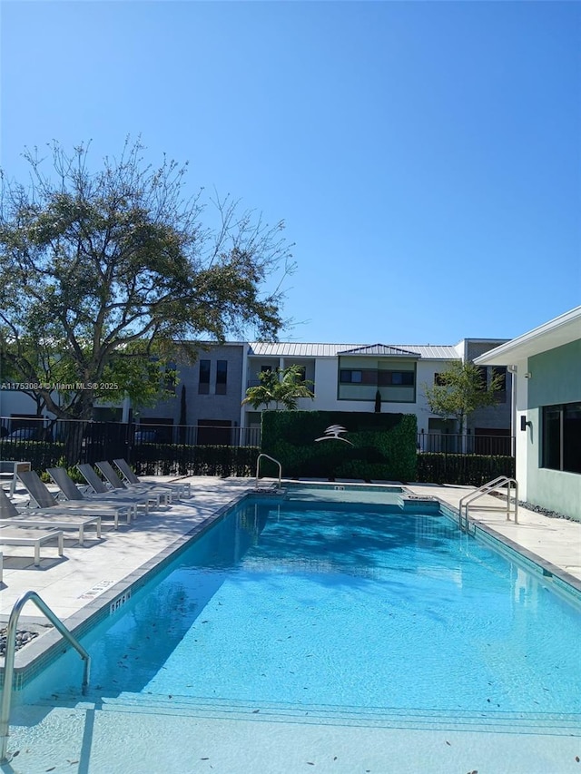 community pool with a patio and fence