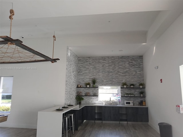 kitchen featuring light countertops, open shelves, light wood finished floors, and white microwave