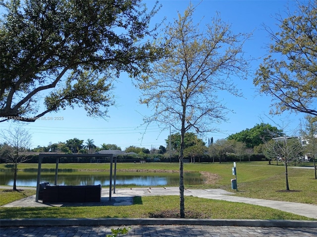 view of community featuring a water view and a yard