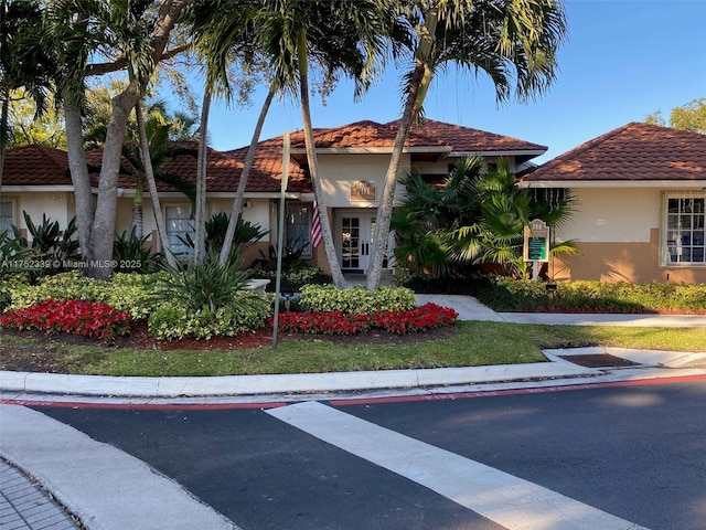 mediterranean / spanish-style house featuring a tiled roof and stucco siding