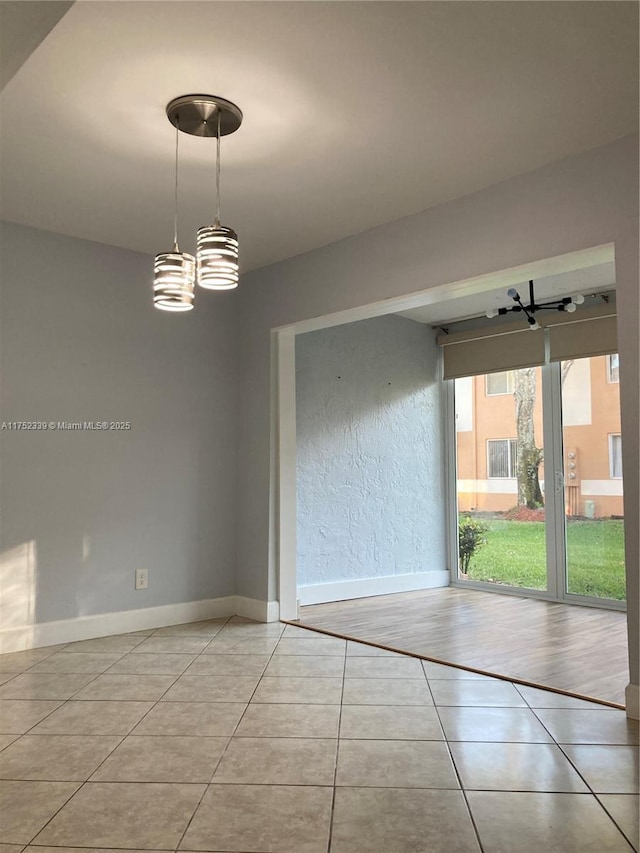 empty room with light tile patterned flooring and baseboards