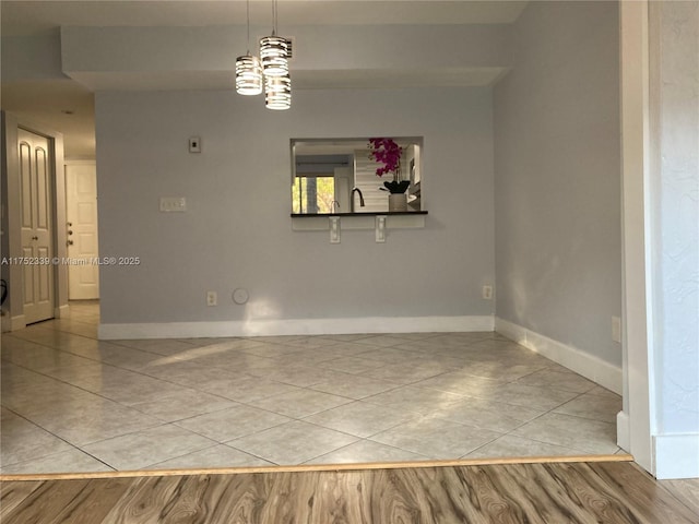 spare room with light tile patterned floors and baseboards