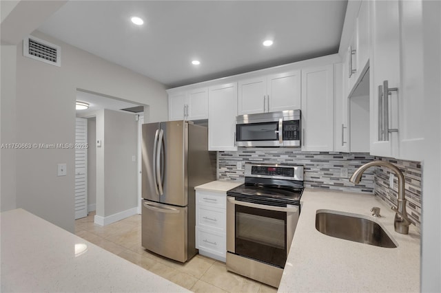 kitchen with light tile patterned floors, visible vents, appliances with stainless steel finishes, white cabinets, and a sink