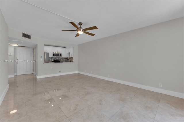 unfurnished living room featuring baseboards, visible vents, and ceiling fan