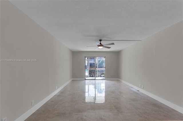 empty room with a textured ceiling, ceiling fan, and baseboards