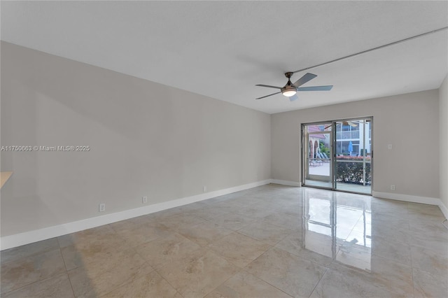 empty room with ceiling fan and baseboards