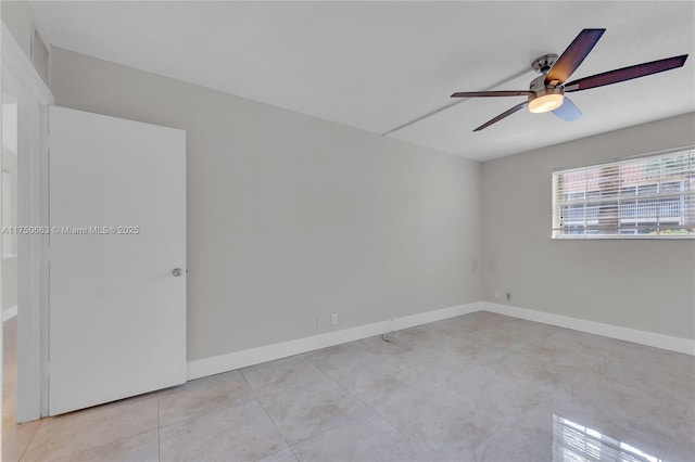 spare room featuring a ceiling fan, baseboards, and light tile patterned floors