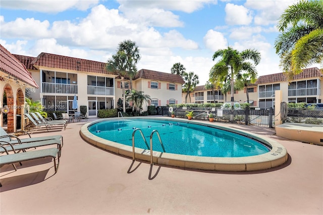 pool with a patio and fence