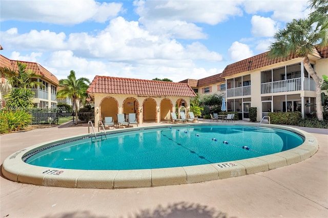 pool with a patio area and fence