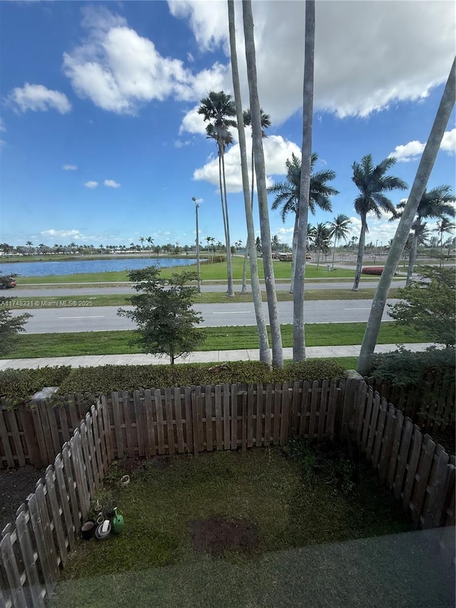 view of yard featuring a water view and fence