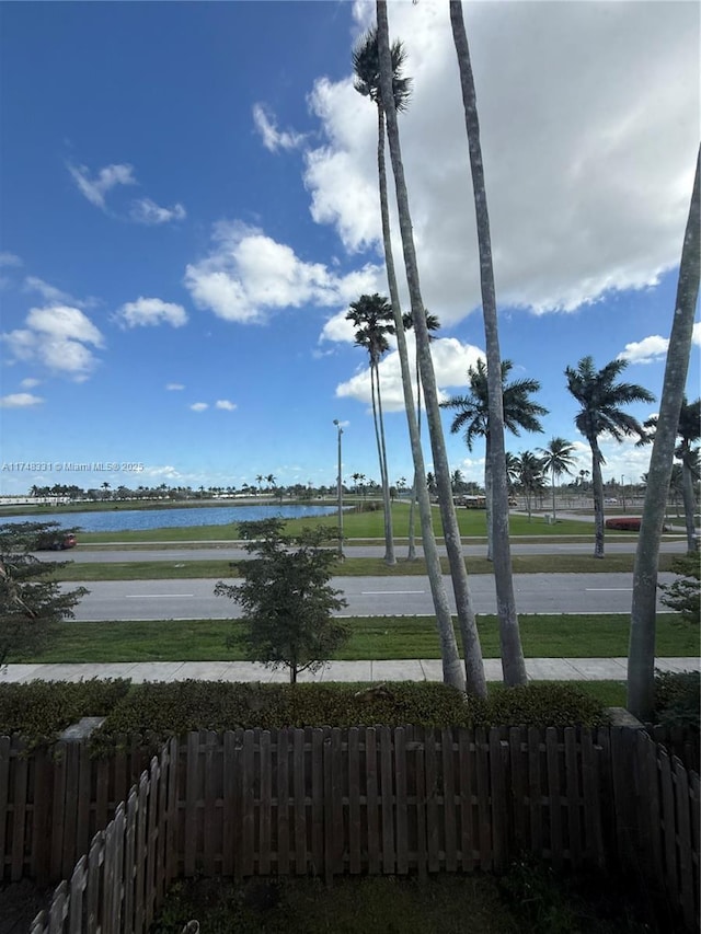 exterior space with a water view and fence