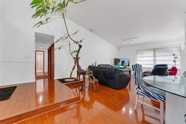 living area with rail lighting, baseboards, visible vents, and hardwood / wood-style floors