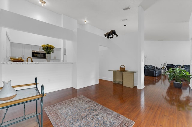 dining space featuring baseboards, wood finished floors, and visible vents