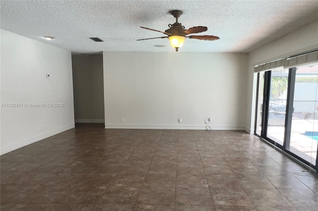 unfurnished room with visible vents, ceiling fan, baseboards, and a textured ceiling