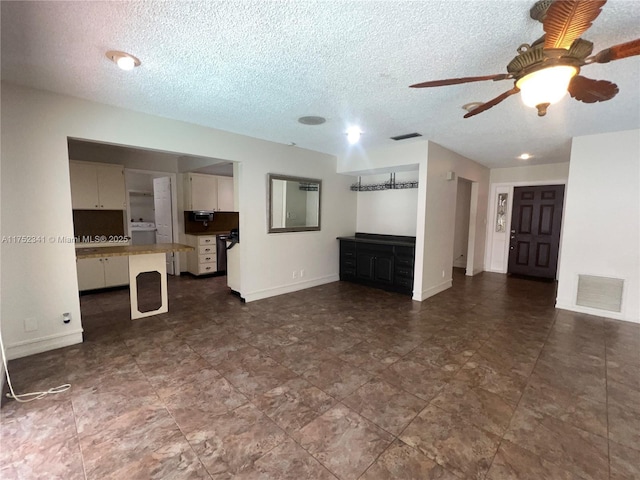 unfurnished living room with visible vents, washer / clothes dryer, a ceiling fan, and a textured ceiling