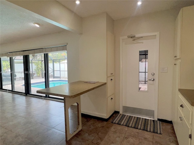 entryway featuring tile patterned floors, baseboards, and recessed lighting
