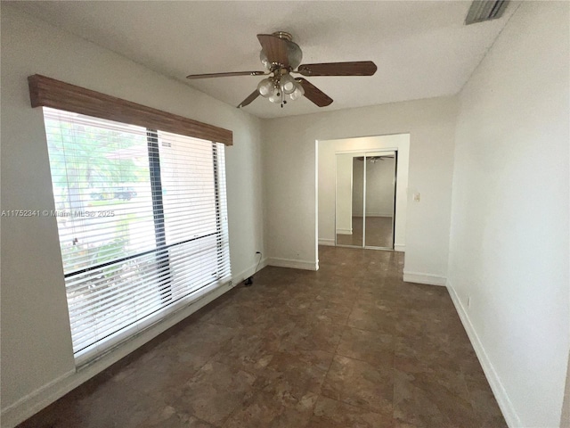 spare room featuring visible vents, baseboards, and a ceiling fan