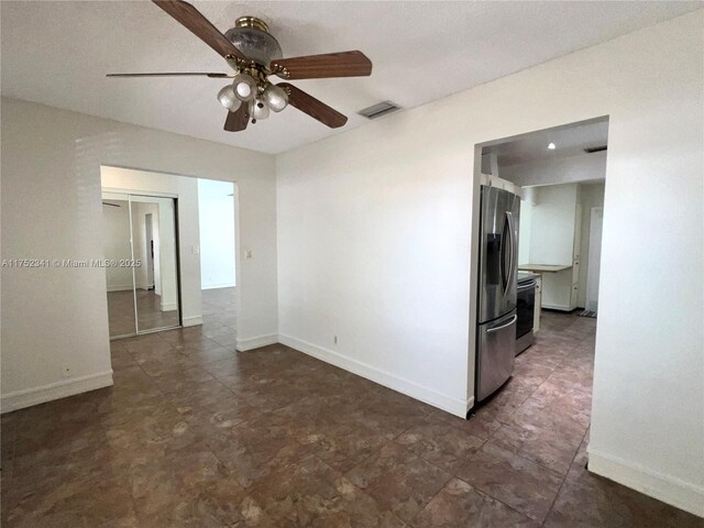 unfurnished room with visible vents, ceiling fan, and baseboards
