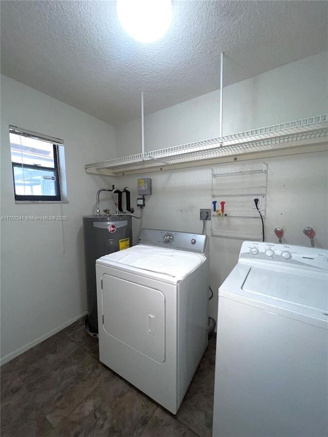 laundry room featuring water heater, washer and dryer, laundry area, and a textured ceiling