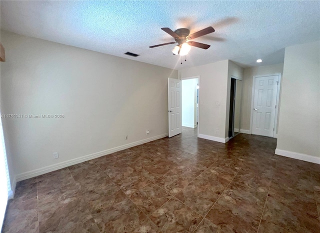 spare room with visible vents, baseboards, a ceiling fan, and a textured ceiling