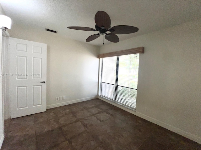 spare room with visible vents, baseboards, and ceiling fan