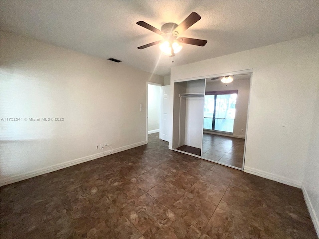 unfurnished bedroom with visible vents, a closet, baseboards, a textured ceiling, and ceiling fan