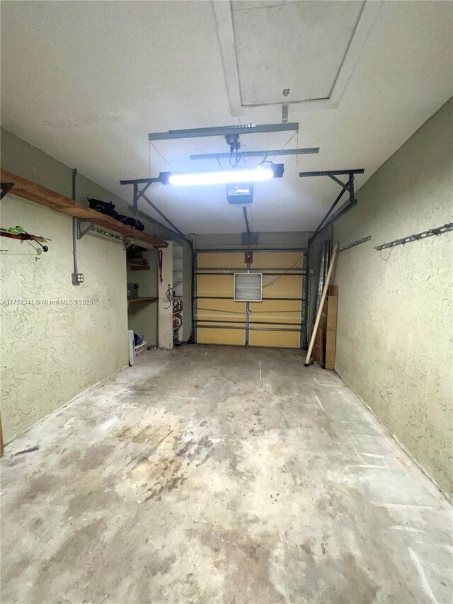 garage with a textured wall and a garage door opener
