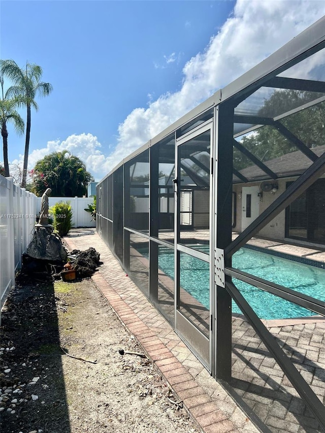 view of swimming pool featuring a fenced backyard, a fenced in pool, a patio, and a lanai