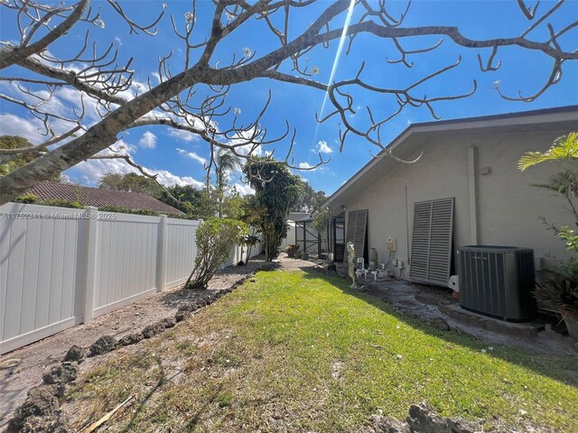view of yard with a fenced backyard and central AC