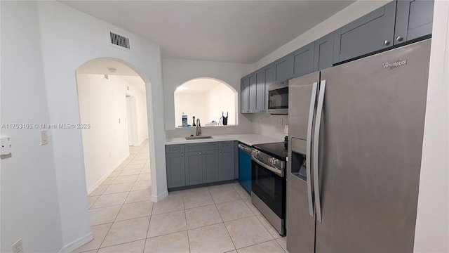 kitchen featuring light tile patterned flooring, a sink, visible vents, light countertops, and appliances with stainless steel finishes