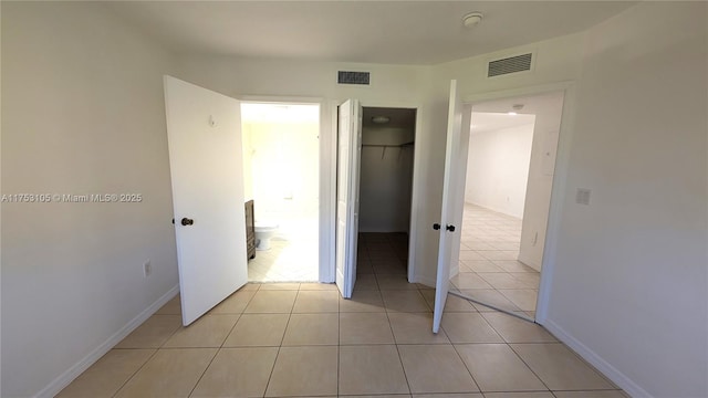 unfurnished bedroom with visible vents, a closet, and light tile patterned flooring