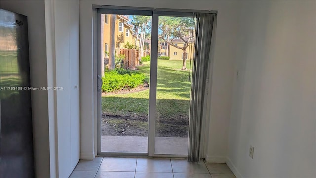 entryway with a healthy amount of sunlight, baseboards, and light tile patterned floors