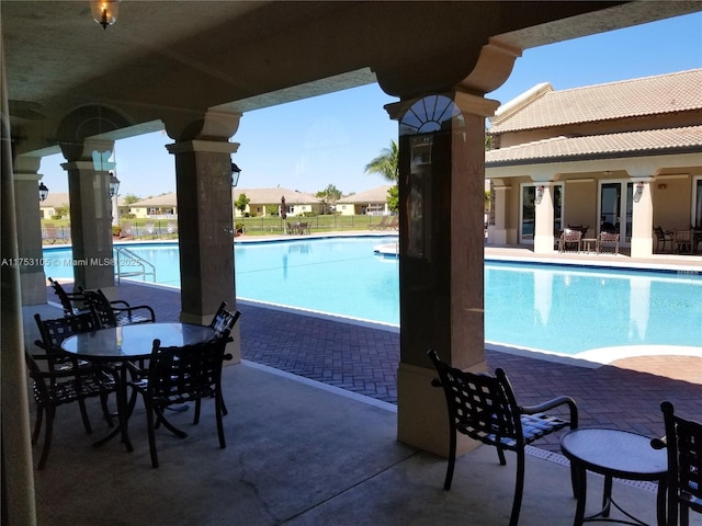 pool with a patio area and fence